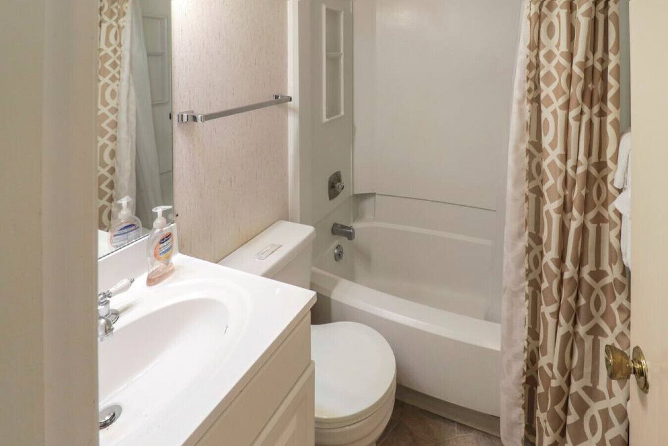 A bathroom with a toilet, sink, and bathtub.