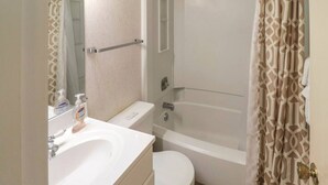 Een badkamer met toilet, wastafel en bad.