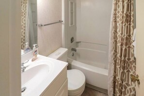 A bathroom with a toilet, sink, and bathtub.