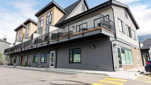 Un immeuble à plusieurs étages doté d’un balcon au deuxième étage, de grandes fenêtres et d’une porte de garage.