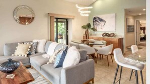 Una sala moderna con sofá, mesa de centro y comedor.