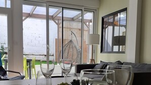 A dining area with a table set for four, including plates, wine glasses, and a centerpiece of succulents. - KALEE Garden apartment (Lanester)