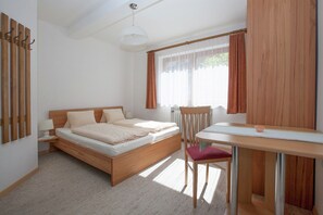 Une chambre à coucher avec un lit en bois, un bureau et une chaise.