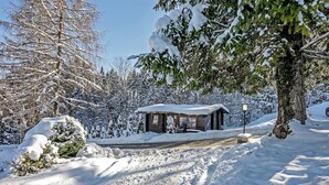 Un paysage enneigé avec une cabane en bois et un ciel dégagé.