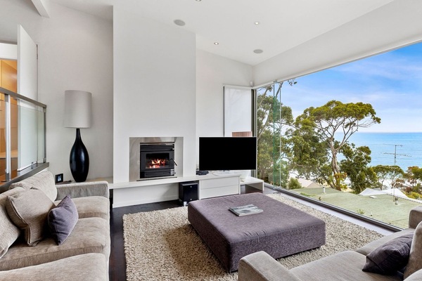The upstairs living room has stylish furnishings and a fireplace to keep you cosy.