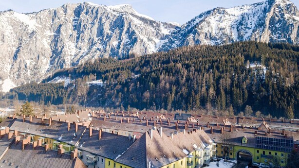 A town with traditional architecture, a central square, and snow-covered mountains in the background. - Lush apartment in Styria with infrared sauna (No Deposit) (Eisenerz)