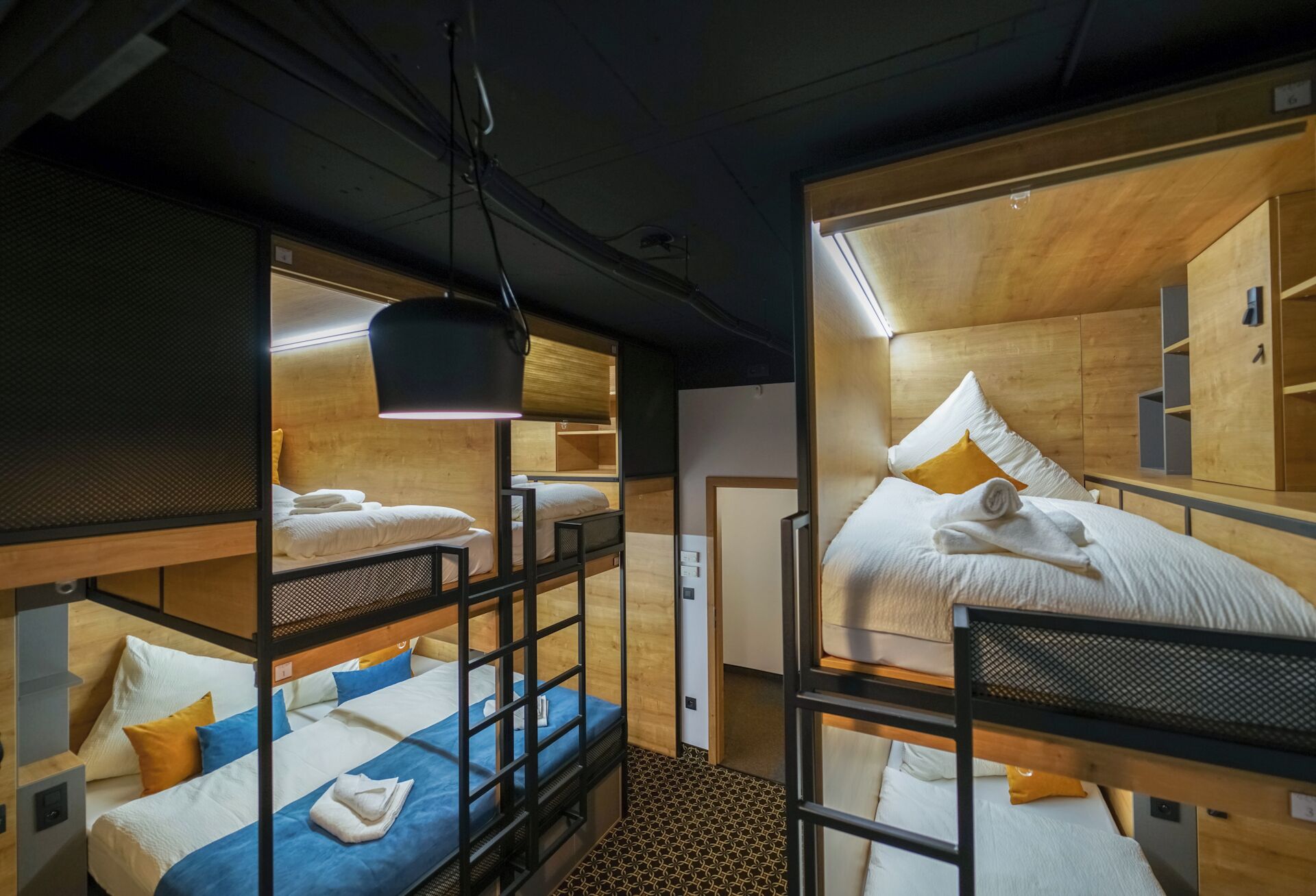 A compact hotel room with bunk beds, a small desk, and a mirror.
