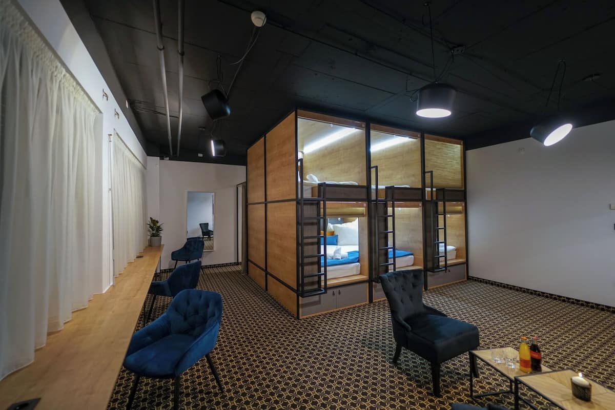 A modern office space with a large open area, a meeting room, and a kitchenette.