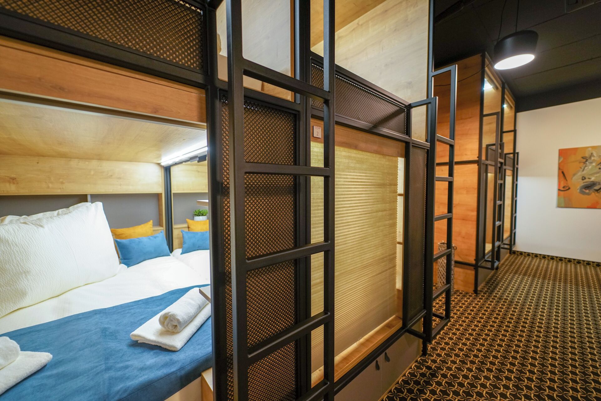 A hotel room with a bunk bed, a small desk, and a window with a view.