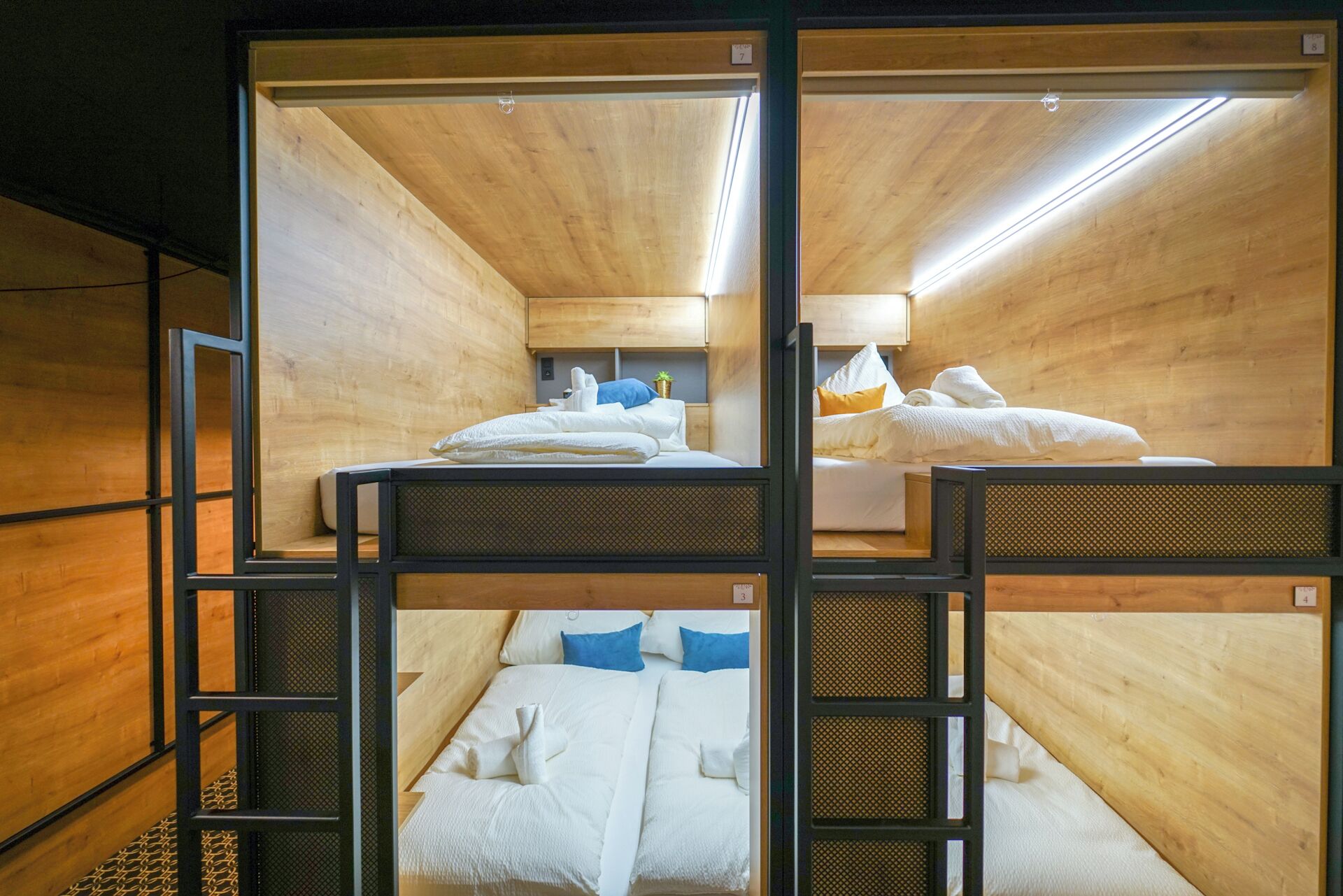A bunk bed room with wooden walls and metal railings.