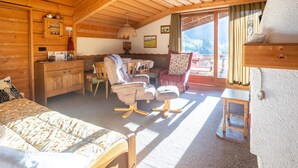 Una cabaña de madera acogedora con una cama, un escritorio, una silla y un sofá.