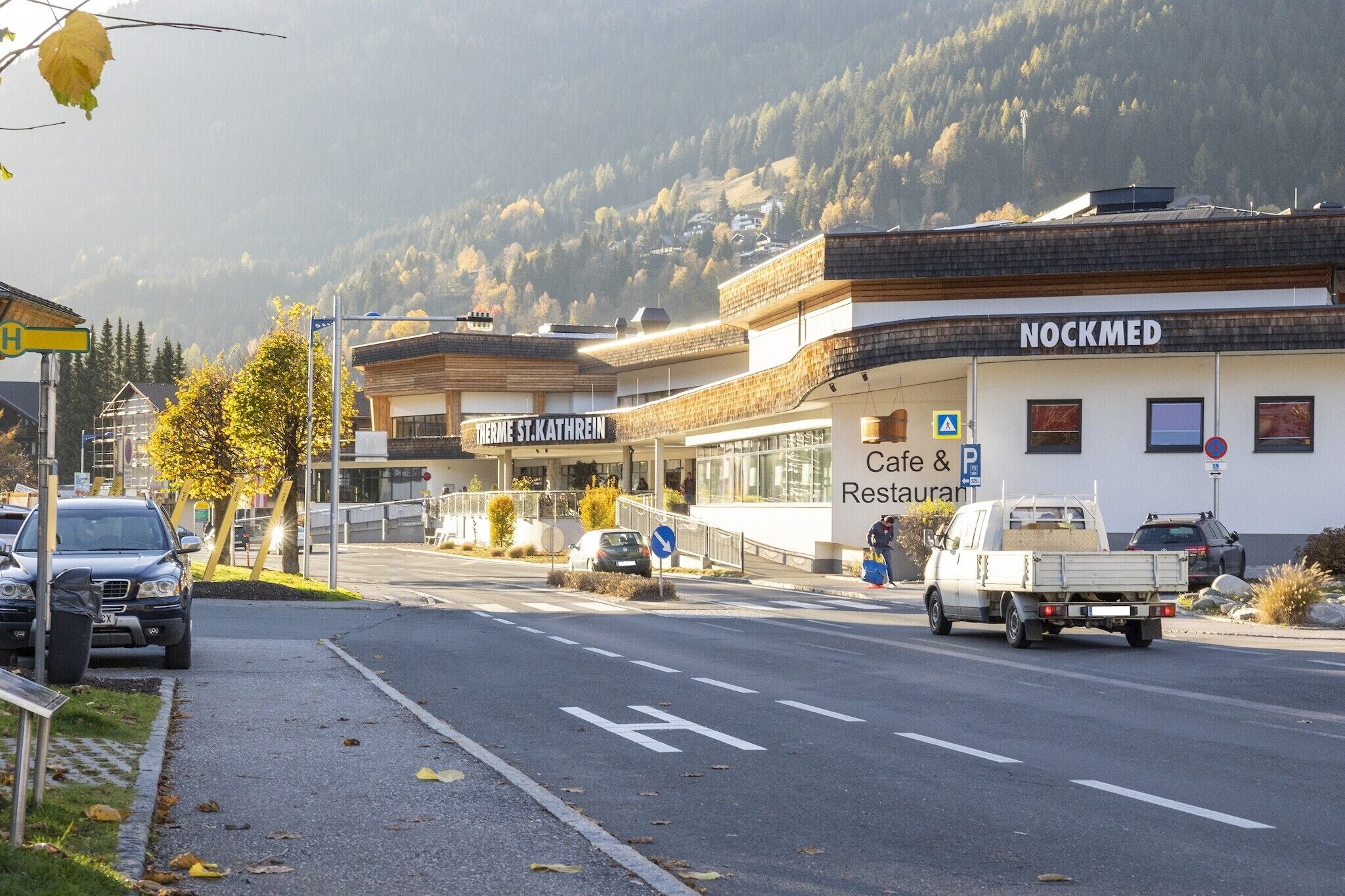 Ein Gebäude mit Café und Restaurant, ein Parkplatzschild und ein Schild für 'Nockmed'.