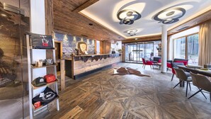 Un interior moderno con suelo de madera, una zona de bar central y diferentes disposiciones de asientos.