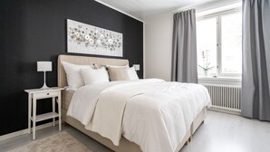 A bedroom with a bed, bedside tables, a window with curtains, and a wall art piece. - Luminous 1br next to Puu-Vallilla (Helsinki)