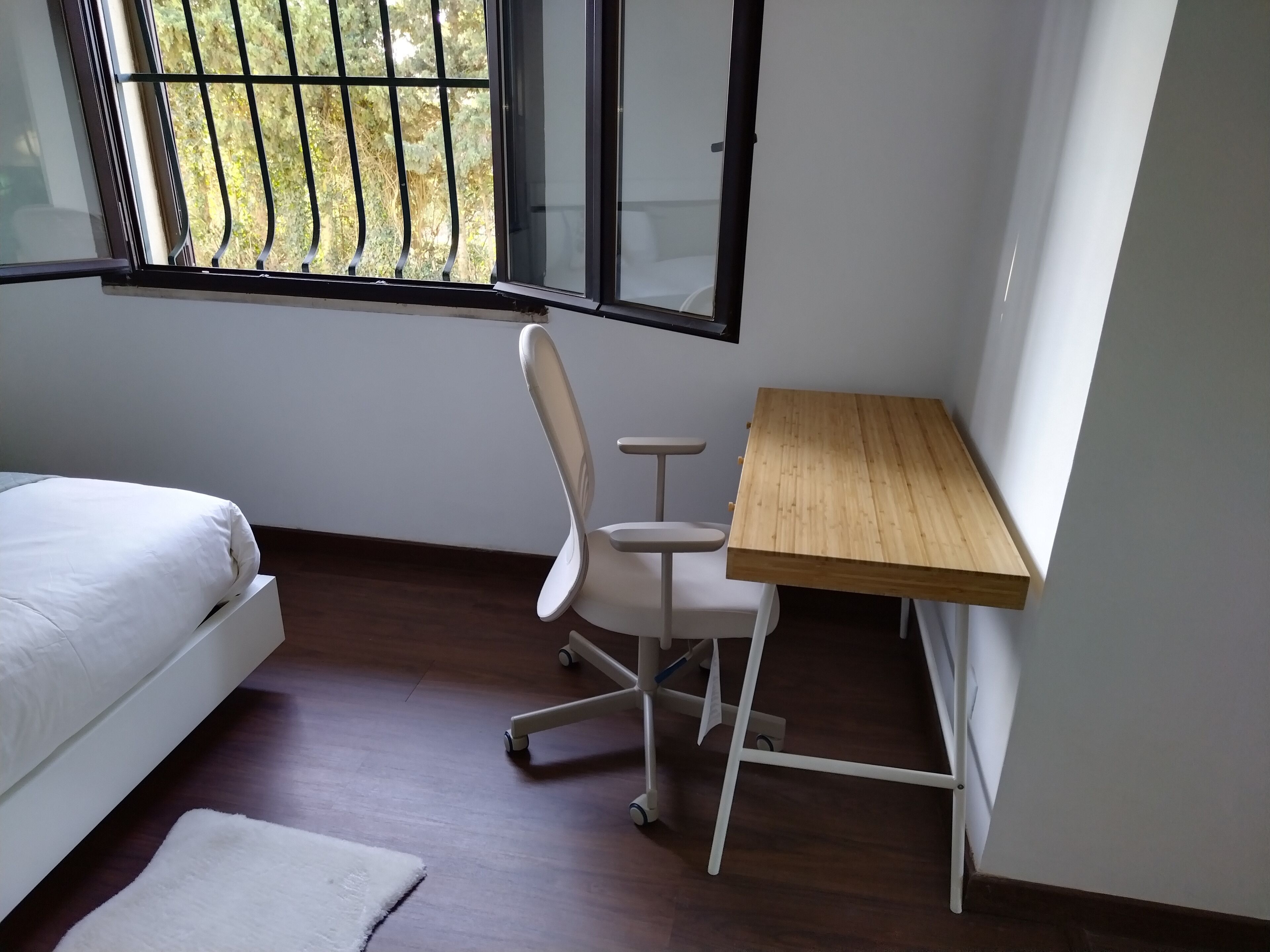 Une chambre à coucher avec un lit, un bureau et une chaise.