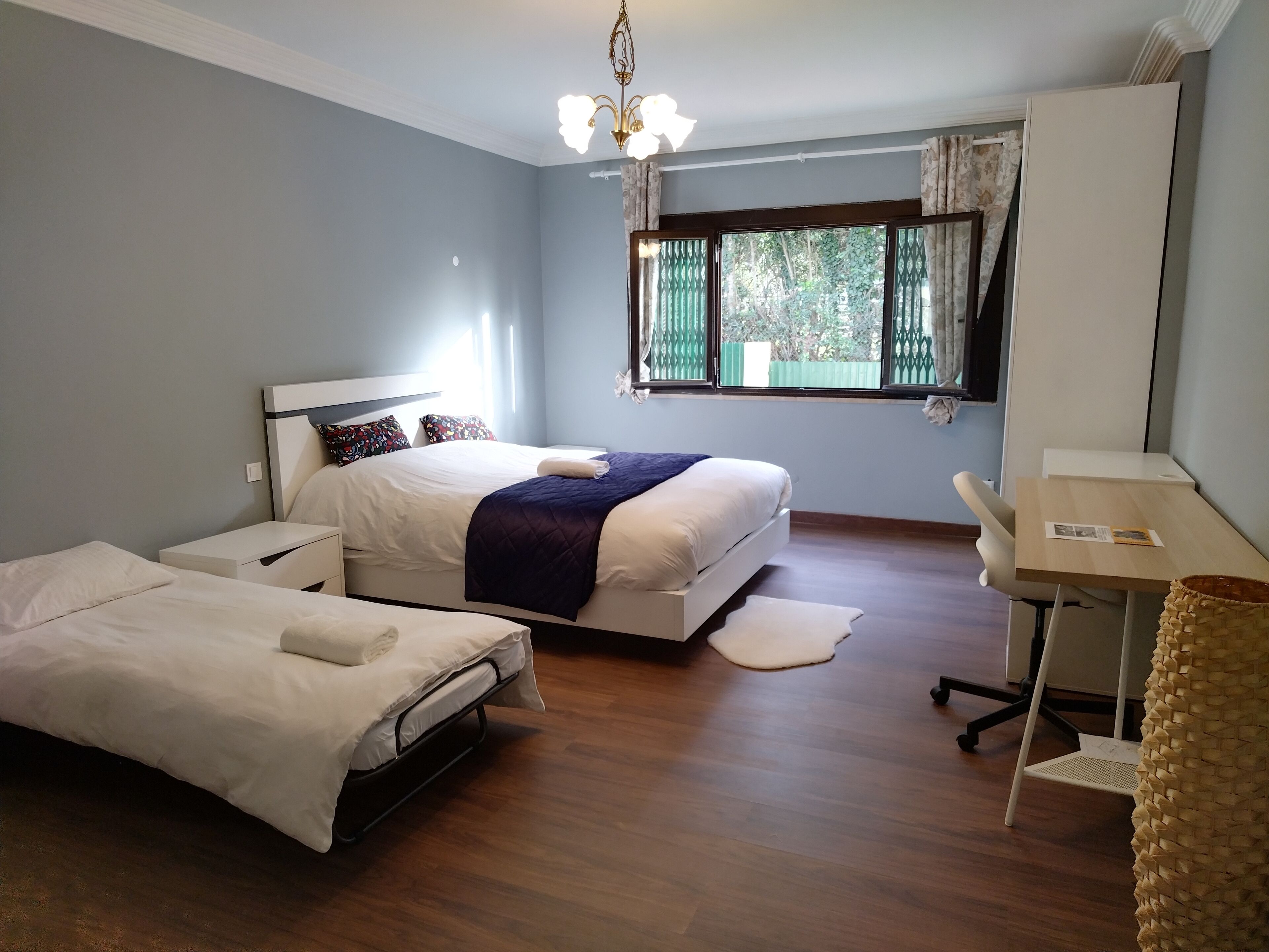 A hotel room with a bed, a desk, and a chair.
