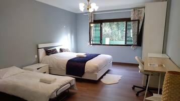 A hotel room with a bed, a desk, and a chair.