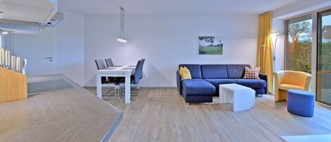 Una sala de estar moderna con un sofá, una mesa de centro y un comedor.