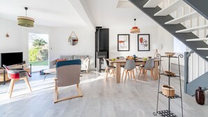 Un salon moderne comprenant un coin repas, un escalier et une cuisine.