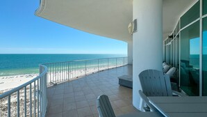 A balcony with a view of the beach and ocean.