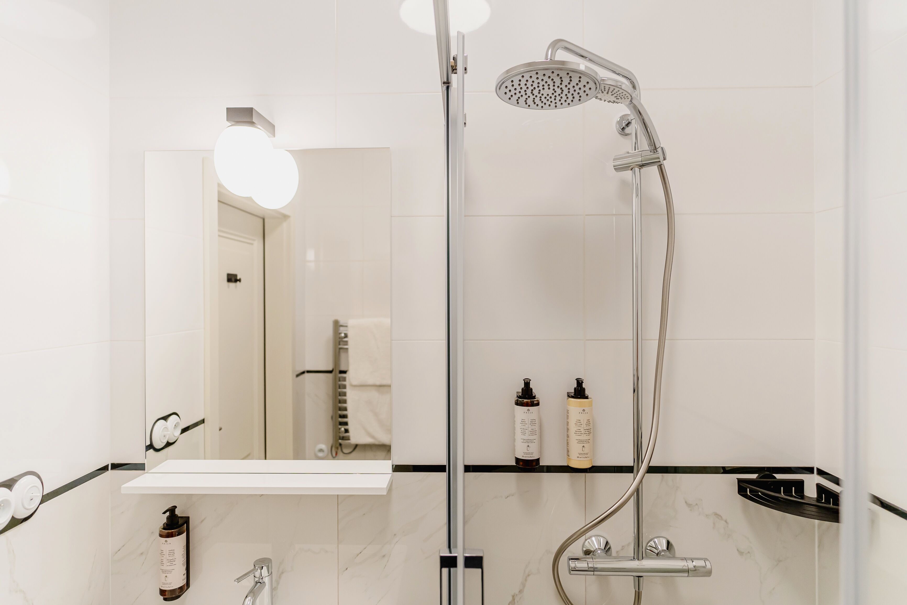 Une salle de bain moderne avec une douche, un miroir et un lavabo.