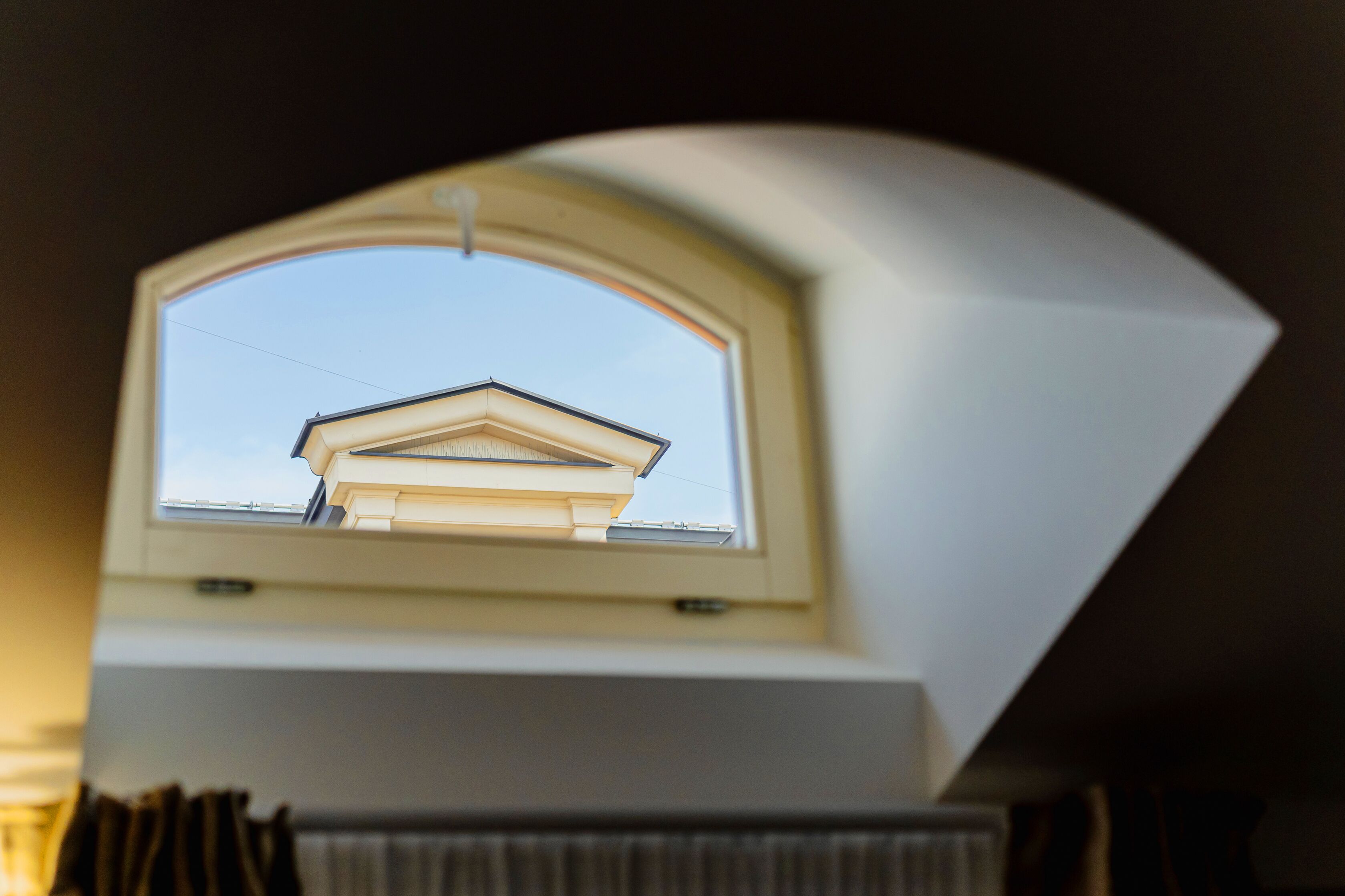 Une lucarne offrant une vue sur le toit d’un bâtiment.