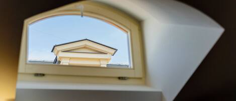 Une lucarne offrant une vue sur le toit d’un bâtiment.