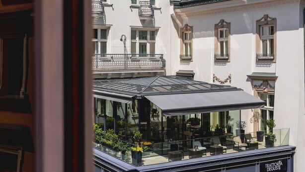 A view of a building with a balcony and a sign that reads "TRATTORIA D'OGGI". - N33 Premium Apartments Old Town Kraków – Destigo Hotels (Kraków)