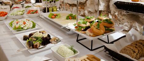 A buffet with various food items including sandwiches, salads, and bread.