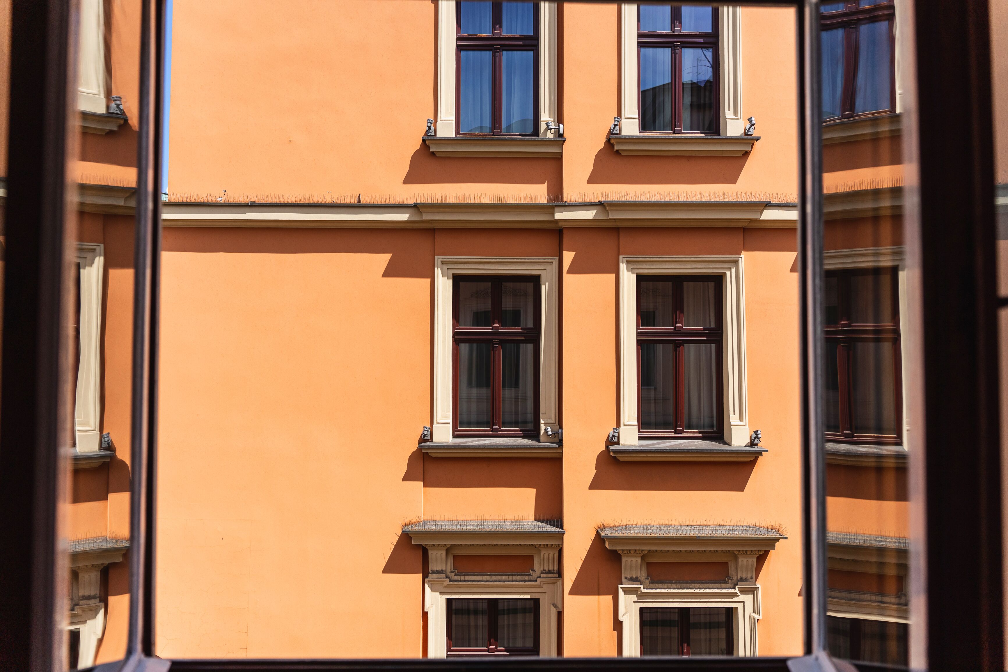 Fachada de edificio con múltiples ventanas y un diseño simétrico.