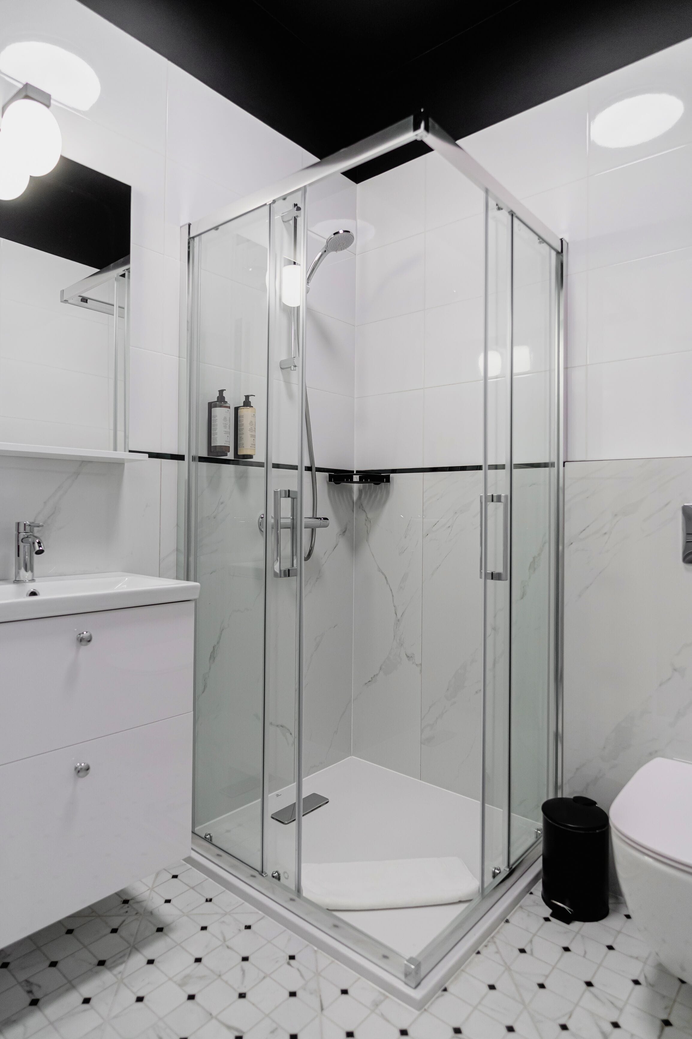 Un bagno moderno con doccia vetrata, lavandino e WC.