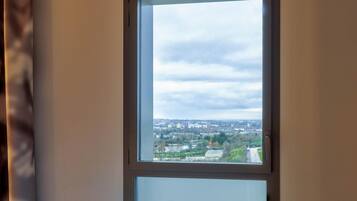 Una ventana con vista a un paisaje urbano, un marco de puerta y una manija.