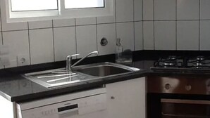 Une cuisine équipée d’un lave-vaisselle, d’un évier, d’une cuisinière et de placards.