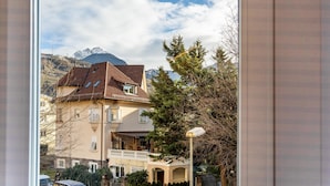 Un edificio residencial con balcón, farola y montaña al fondo.