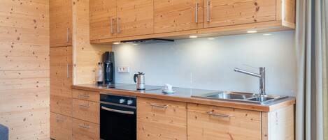 A modern kitchen with wooden cabinets, stainless steel appliances, and a built-in oven.