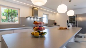 A modern kitchen with a central island, stainless steel appliances, and pendant lighting.