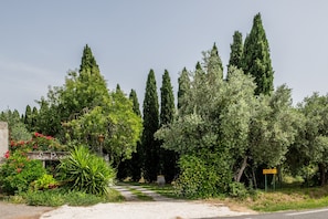 A pathway leading through a garden with tall trees and a sign indicating a private property. - Apartment "Agriturismo La Pieve - Mimose" with Shared Pool, Shared Garden & Wi-Fi (Magliano in Toscana)