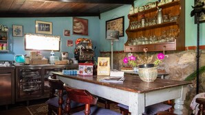Una cocina rústica con armarios de madera, una pared de piedra y una mesa de comedor de madera con sillas.