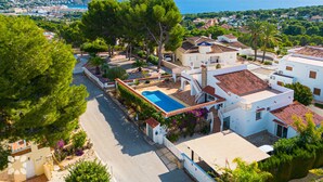 A residential area with a swimming pool, white buildings, and a view of the sea. - Villa PONTE VECCHIO by Abahana Villas (Teulada)