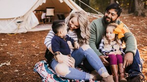 A family sitting on a blanket in a forest with a tent in the background. - Luxury Glamping tent in Ouachita Mountains (Mena)
