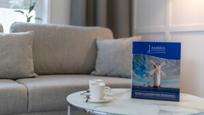 A brochure for Ambria Apartments featuring a windmill, a white cup, and a spoon on a small table.
