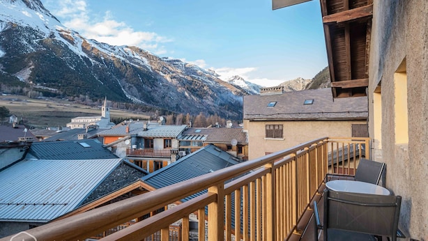 A balcony with a view of a mountainous landscape, wooden railings, and a table with chairs. - Le Temps Suspendu "Chardon Bleu" - Relaxation Stay - Apartment 8 people (TERMIGNON)
