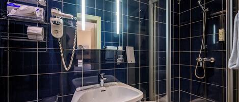 Un bagno moderno con cabina doccia in vetro, lavandino bianco e specchio.