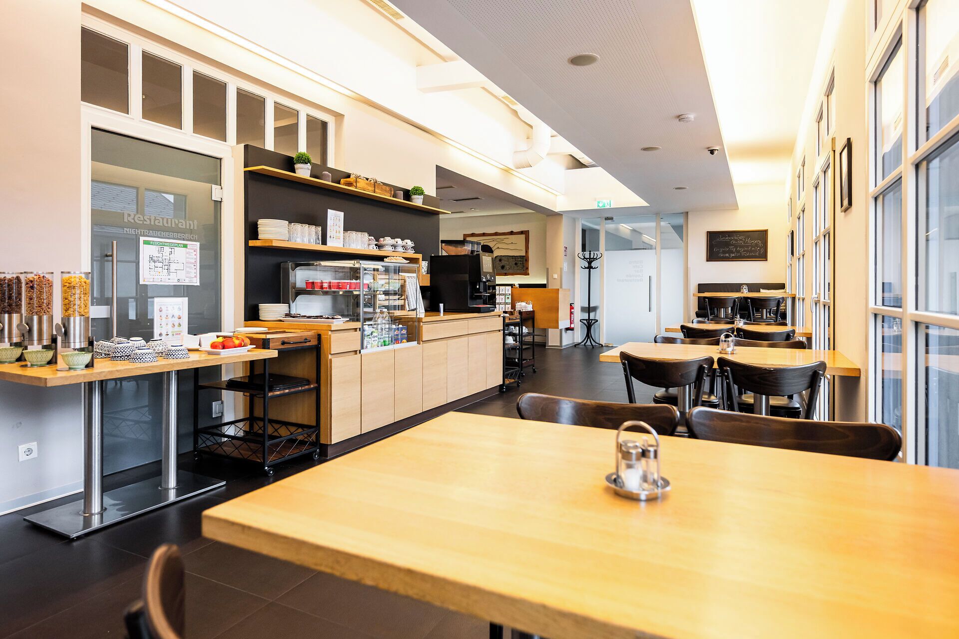Ein modernes Restaurant mit Theke, Sitzbereich und Küche.