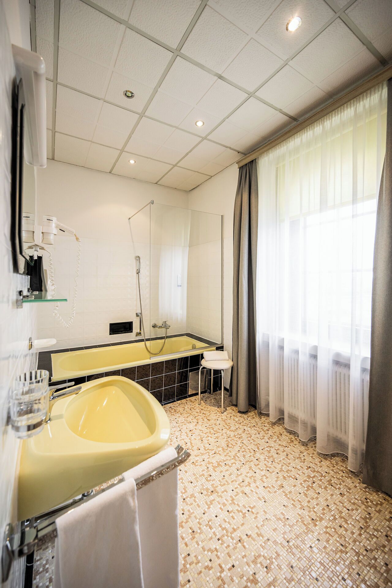 A modern bathroom with a large bathtub, a mirror, and a shower.
