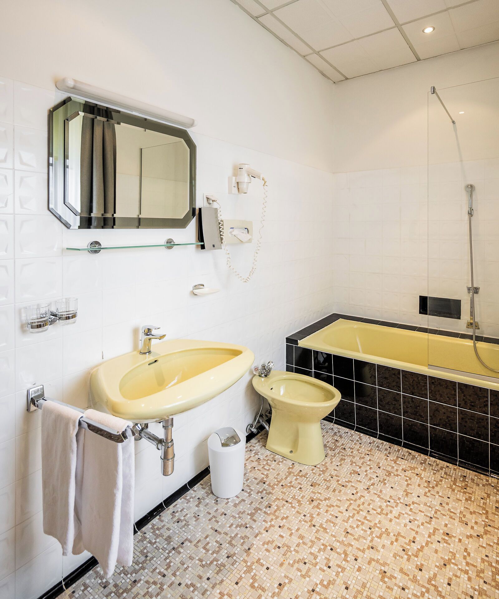 A bathroom with a sink, bidet, and bathtub.