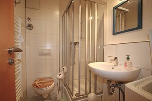 Ein Badezimmer mit Toilette, Duschkabine und Waschbecken.