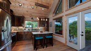 Una cocina moderna con armarios de madera, un refrigerador de acero inoxidable y una isla grande con taburetes de bar.