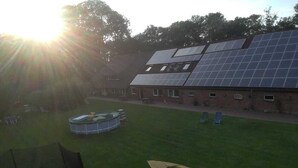Un bâtiment doté d’une installation de panneaux solaires, d’une piscine et d’un bateau.