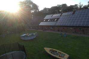 Un bâtiment doté d’une installation de panneaux solaires, d’une piscine et d’un bateau.